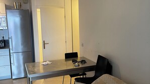 Ein kompakter Wohnbereich mit Küchenzeile, Esstisch und Sofa.