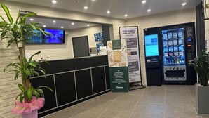 A hotel reception area with a reception desk, a KIOSK, a vending machine, and a signboard. - HOTEL LAVANDA (Incheon)
