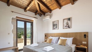 Une chambre à coucher avec un grand lit, une tête de lit en bois et un banc.