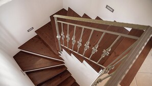 Un escalier en colimaçon avec des marches en bois et des rampes blanches.