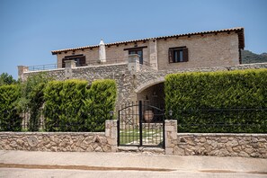 A stone building with a balcony, a gate, and a hedge. - Elegant Countryside Retreat with Private Pool Near Chania (Kirtomados)
