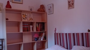 Ein Schlafzimmer mit einem Bett, einem Bücherregal und einer Deckenleuchte.