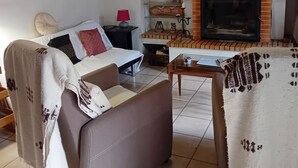 Ein gemütliches Wohnzimmer mit einer Couch, einem Kamin und einer Treppe, die nach oben führt.