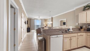 Una cocina moderna con una isla central, lavavajillas y un amplio ventanal con vistas al exterior.