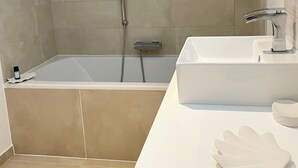 Een moderne badkamer met een bad, een wastafel en een spiegel.