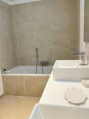 A modern bathroom with a bathtub, a sink, and a mirror. - L'air Marin - Le Tréport apartment - 5-minute walk from the port (Le Tréport)