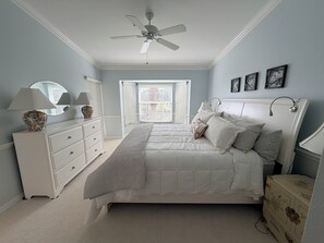 Une chambre à coucher avec un lit, une commode et un ventilateur de plafond.