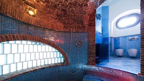 A modern bathroom with a brick wall, a tiled shower area, and a blue-tiled floor. - The Shipowner's Villa - your retreat with a view and patio (Campania)