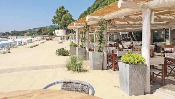 A beachside restaurant with outdoor seating, a sandy beach, and a view of the sea. - Villa With Private Pool, Garden & Panoramic Views (Draguignan)