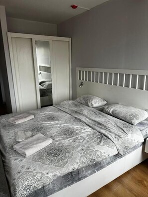 A bedroom with a bed, a wardrobe, and a mirror. - D&D PANSİYON (Istanbul)