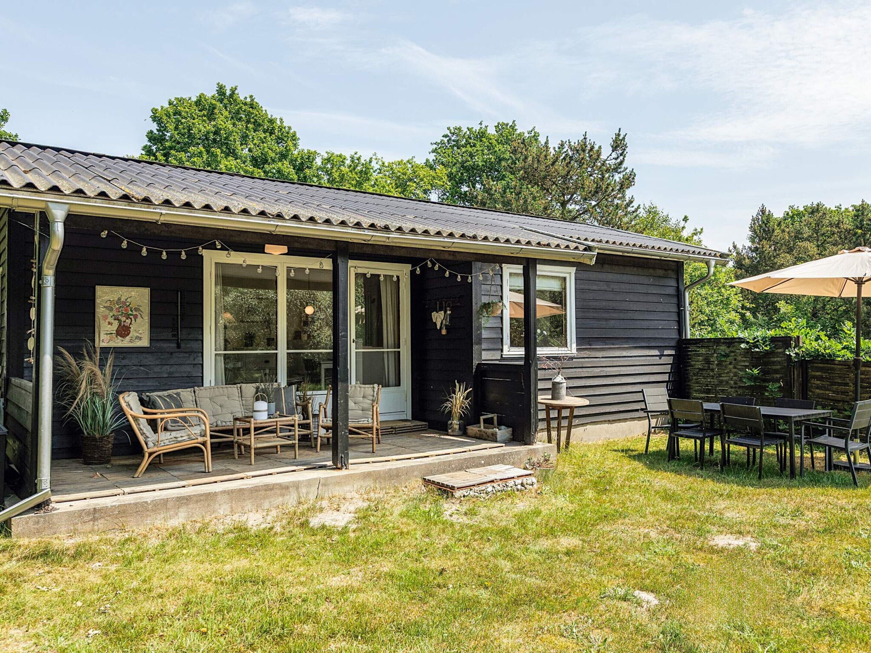 A house with a porch, outdoor seating, and a table.