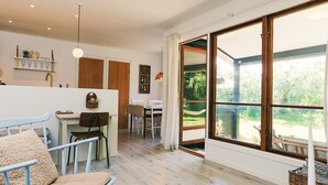 A modern interior with a dining area, kitchen, and large sliding glass doors to a garden. - 5 Person Holiday Home in Rodby (Rodby)