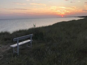 A bench overlooking a body of water with a sunset in the background. - 5 Person Holiday Home in Rodby (Rodby)