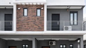 A modern two-story building with a brick facade, large windows, and a flat roof. - Cozy 2 Bedroom Terrace Duplex + Wi-Fi,TV,24/7 Power In Ajah (Lekki/Ajah)