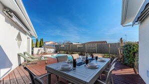 An outdoor patio with a dining table set for four, surrounded by chairs. - Villa with private pool, garden & wood stove (Le Teich)