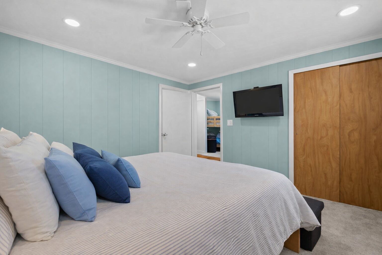 Your coastal retreat features soft blue accents and crisp linens, with gentle ceiling fan breezes keeping you comfortable year-round.