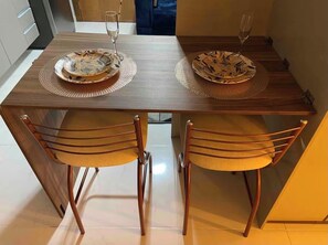 Uma mesa de jantar com duas cadeiras, cada uma com um assento acolchoado em tecido.
