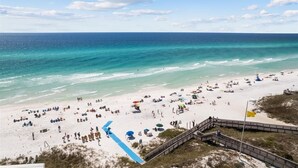 A beach with a wooden boardwalk leading to the water, a sandy beach area with umbrellas, and a clear view of the ocean. - A-Frame of Mind - Stylish Santa Rosa Beach Retreat | Walk to Beach (Santa Rosa Beach)