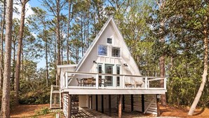 A cabin with a balcony, surrounded by trees. - A-Frame of Mind - Stylish Santa Rosa Beach Retreat | Walk to Beach (Santa Rosa Beach)