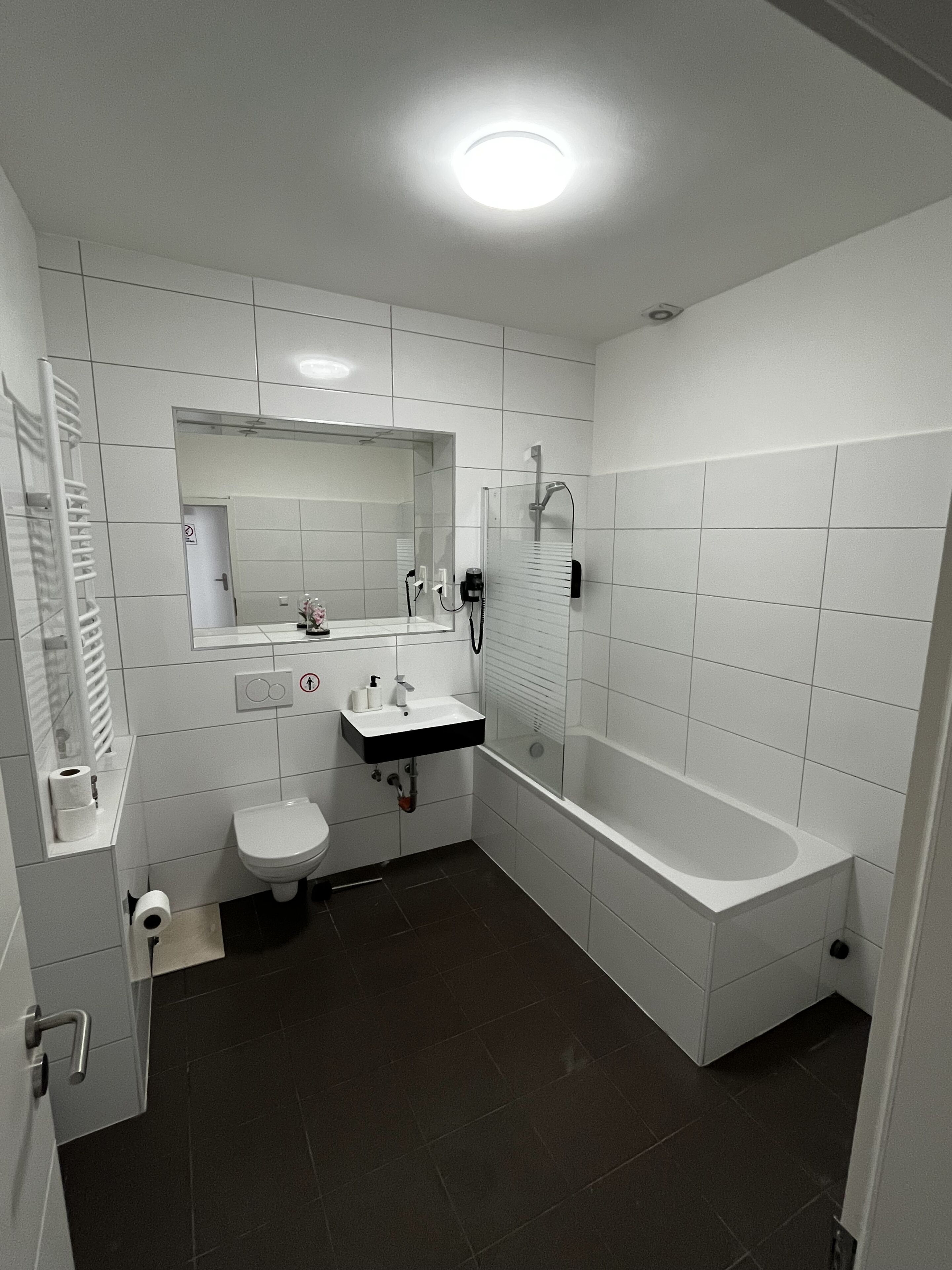 A modern bathroom with a toilet, sink, and bathtub.