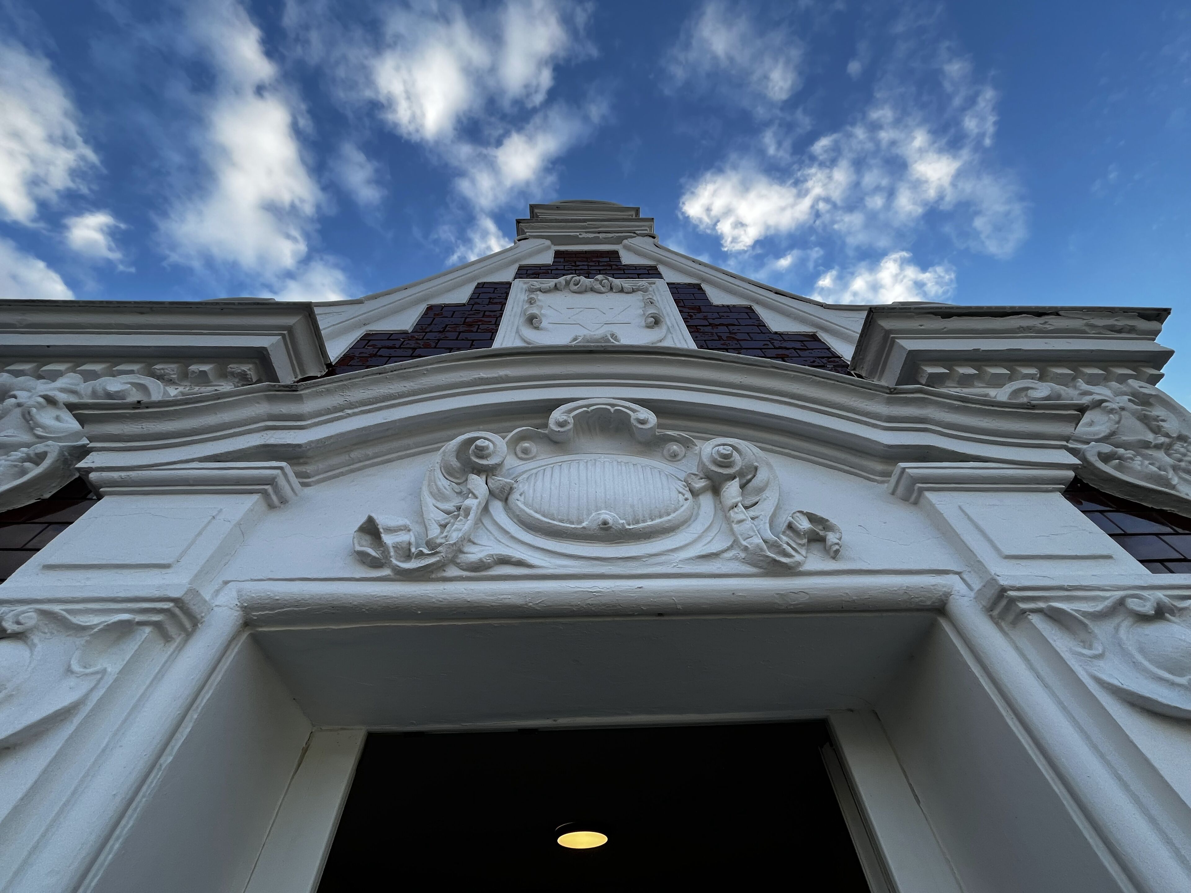 A building's ornate entrance with detailed carvings and a clear sky above.