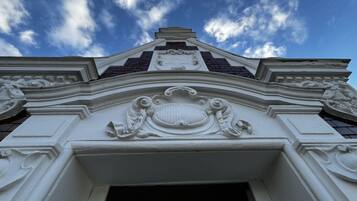 A building's ornate entrance with detailed carvings and a clear sky above.