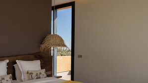A modern bedroom with a large bed, a woven ceiling light, and a view of the outdoors. - Exclusive villa with 5 suites, heated pool and panoramic view (Marrakech)