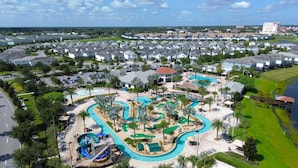 Ein Resort mit großem Schwimmbecken, einer Wasserrutsche und einem Golfplatz.