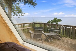 Une terrasse avec vue sur la mer, des meubles en bois et une rambarde en bois.