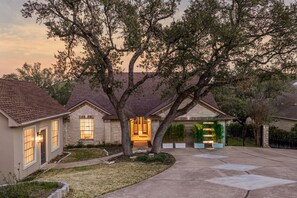 A residential house with a driveway, a front yard, and a garage. - ~Santorini on Travis~ Lakefront | Boat Slip | Pool (Leander)