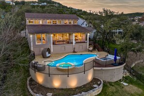 A two-story house with a swimming pool, outdoor seating area, and a covered patio. - ~Santorini on Travis~ Lakefront | Boat Slip | Pool (Leander)