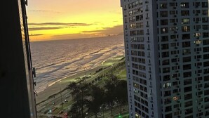 Un edificio alto con varios pisos y vistas al atardecer sobre el océano.