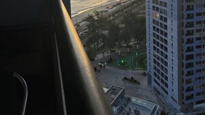 Un rascacielos con vista al océano al atardecer.