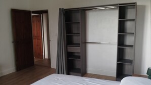 Een slaapkamer met een bed, een kledingkast en een deur.
