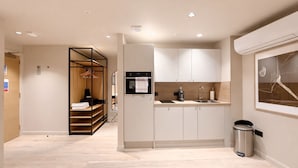 A modern kitchen with a built-in oven, a sink, and a trash bin.
