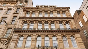 Un edificio histórico con detalles arquitectónicos ornamentales, incluyendo ventanas en arco y elaborada cantería.