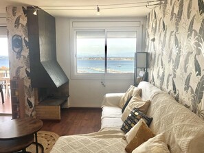 Un salon avec une cheminée, un canapé et une vue sur la mer.