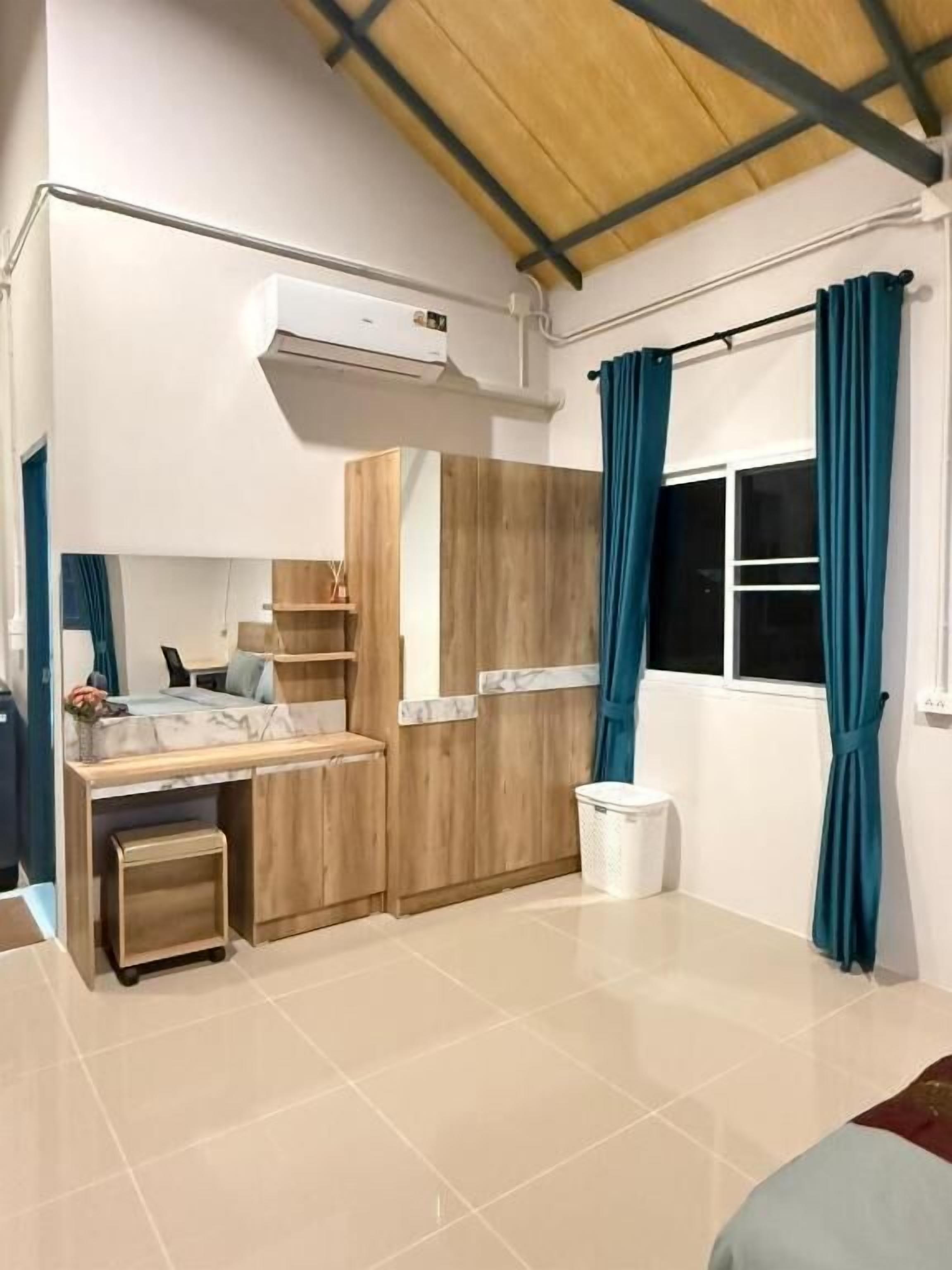 A compact bedroom with a bed, a desk, and a wardrobe.