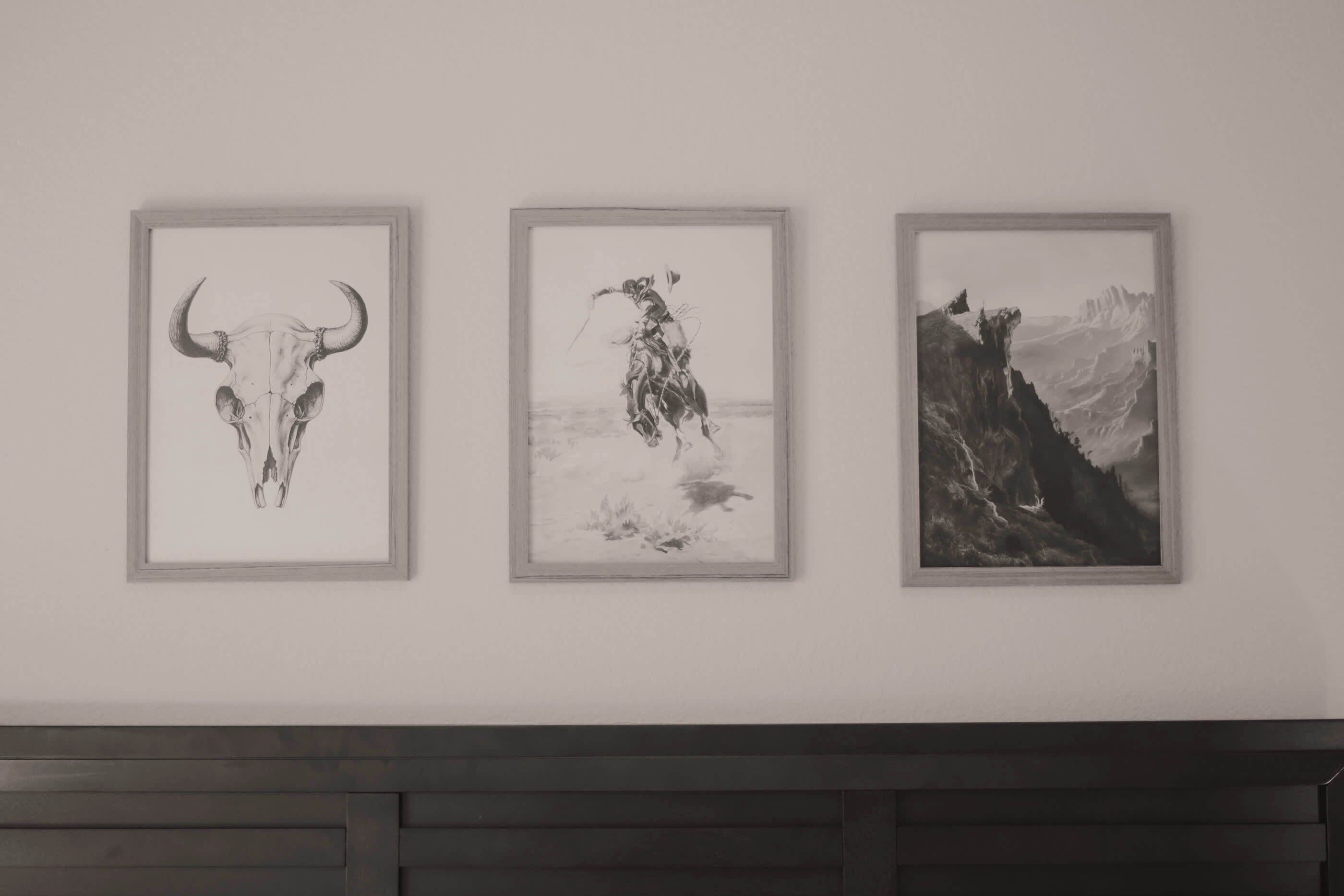 Drei gerahmte Kunstwerke an einer Wand.