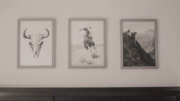 Drei gerahmte Kunstwerke an einer Wand.