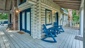 A log cabin with a porch, blue rocking chairs, and a table. - Resort Setting*Close to Pigeon Forge*Romantic (PIGEON FORGE)