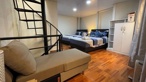 A bedroom with a bed, a sofa, a wardrobe, and a staircase. - Mini-apartment of 02 floors, centrally located and comfortable (Cusco)