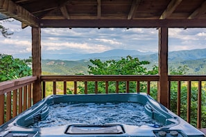A hot tub with a wooden deck and a view of mountains. - Endless Mountains From Porch Swings In The Sky (PIGEON FORGE)