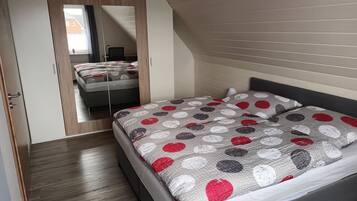 Een slaapkamer met een bed, een kledingkast en een spiegel.