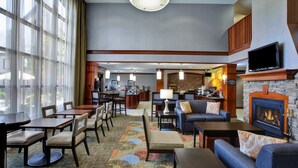 Eine großzügige Lobby mit Kamin, bequemen Sitzgelegenheiten und einer Bar.