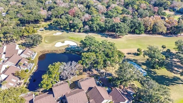 Luchtbeeld van een woongebied met huizen, een golfbaan en een groot wateroppervlak.
