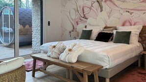 Een moderne slaapkamer met een groot bed, een bankje en uitzicht op de omgeving.