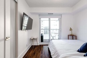Bedroom featuring a cozy Queen-sized bed and direct access to the balcony - Luxury 3BR Condo: Near MTCC & CN Tower + Parking (Toronto)