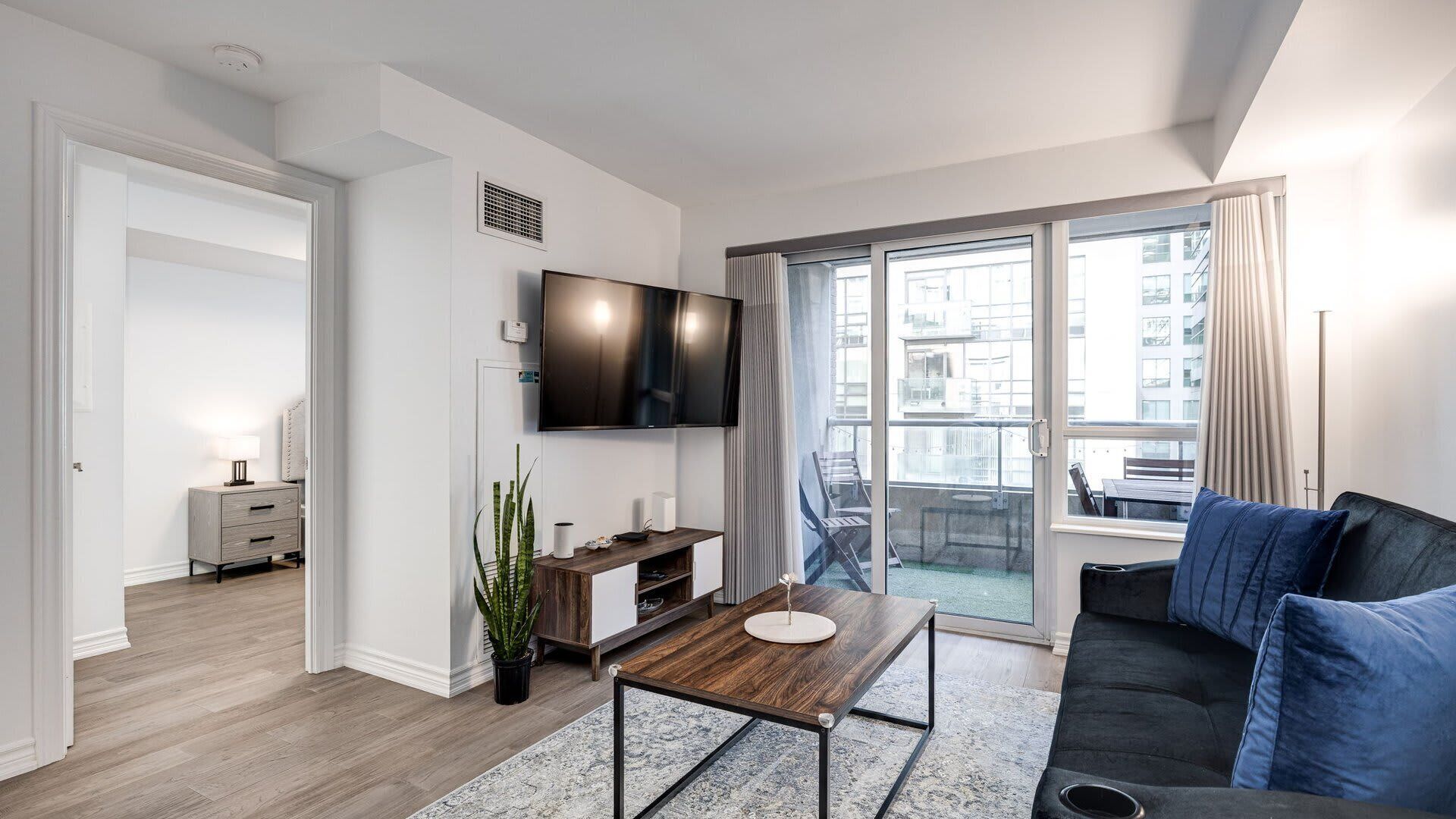 Pristine living room enriched with an abundance of natural light from the window and glass door.