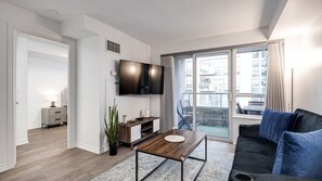 Pristine living room enriched with an abundance of natural light from the window and glass door. - Urban APT w/ Highspeed Wi-Fi •Near shopping malls! (Toronto)